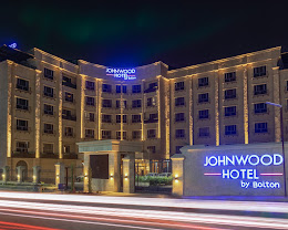 The illuminated night facade of Johnwood Hotel by Bolton, Abuja