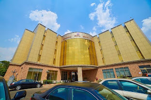 The gold-panelled facade and portico entrance of Corinthians Hotel, Abuja
