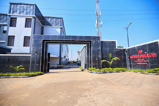 The black stone gatehouse and driveway entrance of Bourdillon Hotel, Abuja