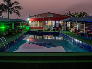 The floodlit poolside terrace of Hotel de Bentley at dusk, Abuja