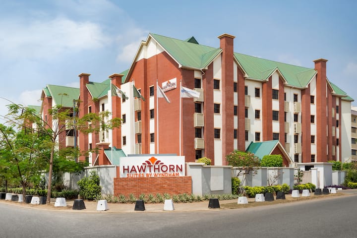 The red-brick and green-roofed exterior of Hawthorn Suites by Wyndham, Abuja
