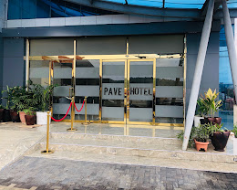 The gold-framed glass entrance doors of Pave Hotel, Abuja