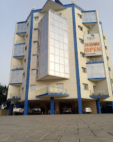 The blue and white multi-storey exterior of Blue Spring Hotel, Abuja